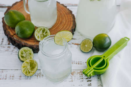 Lemonade with lime and mint in a glass jar on a white wooden backgroundの写真素材