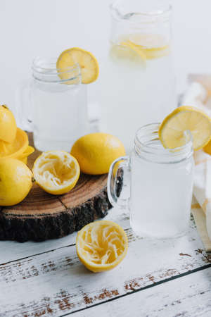 Lemonade in a glass jar and lemon on a wooden backgroundの写真素材