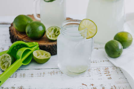 Lemonade with fresh limes on a white wooden background.の写真素材