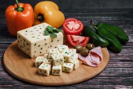 Cheese plate with ham, olives, tomatoes and peppers on wooden backgroundの写真素材