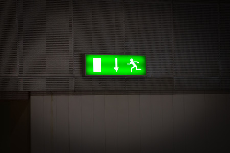 Emergency exit sign above a black doorwayの写真素材