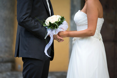 Bride and Groom Holding Hands Outdoors in a Wedding Dayの写真素材