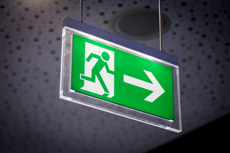 Emergency exit light sign on a gray backgroundの写真素材