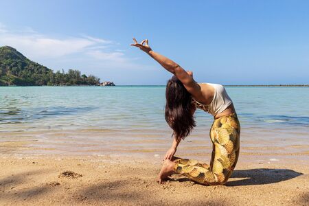 Asian Thai woman practicing yoga at evening in Haad Chaloklum beach, Koh Phangan island, Thailand. Camel pose.の写真素材