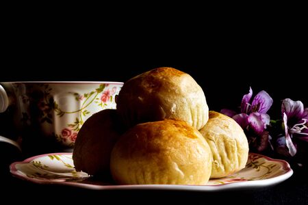Traditional chinese cake on a plate with a cup of tea.