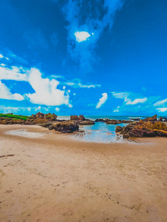 Tropical beach with rocks and blue sky in Bali, Indonesiaの写真素材