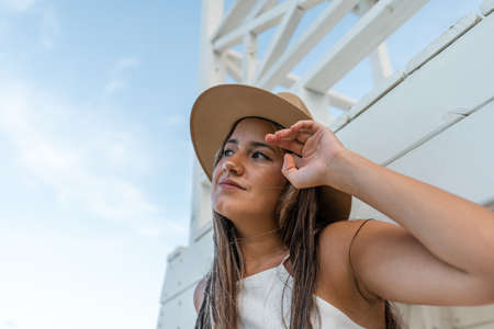 young model with hat on the beach at sunsetの写真素材
