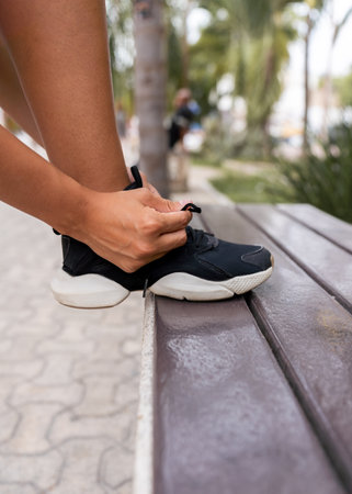hispanic womans hand tying shoelaces of sneakers - sport conceptの写真素材