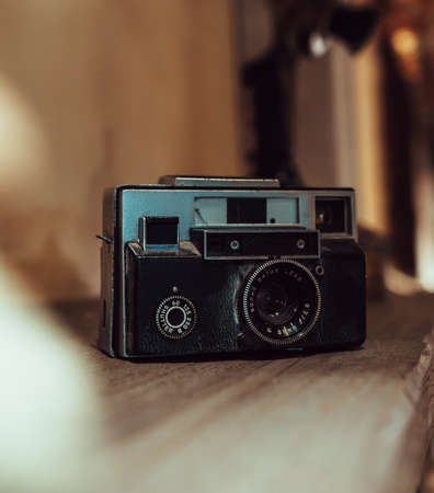 old analog photo camera on a wooden shelfの写真素材