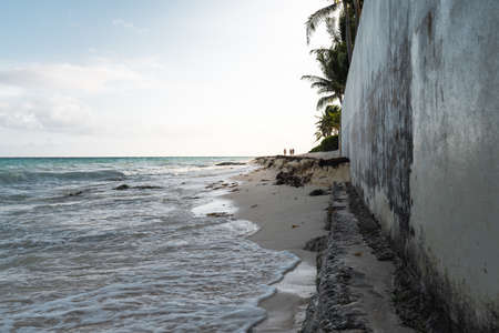 group of unrecognizable people walking along the shore in the distanceの写真素材