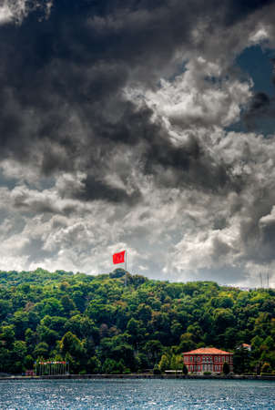 Landscape with a red flag on the background of a stormy skyの写真素材
