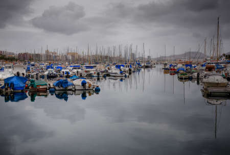 View of the marina with yachts and boats on a cloudy dayの写真素材