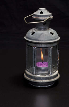 Lantern with a burning candle on a black background. High quality photoの写真素材