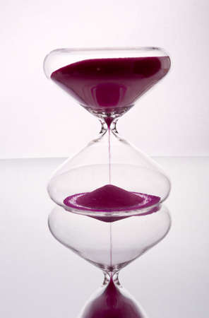 Hourglass with purple sand on a white background. Time concept.