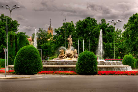 View of the fountain in the city park with a cloudy sky.の写真素材