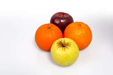 Oranges and apples on a white background, close-up.の写真素材