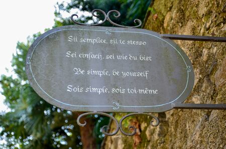 Multilanguage inspirational sentence on an iron sign on a wallの写真素材