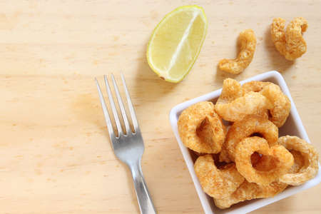 Pork cracklings, appetizer on wooden table.の写真素材
