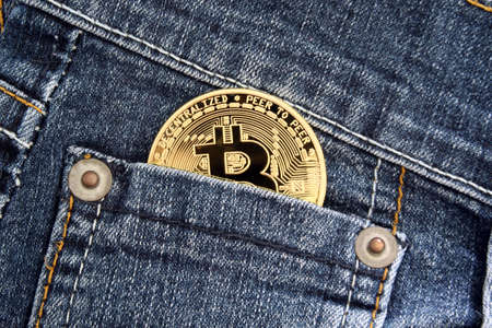 Recife, Pernambuco, Brazil - October 18, 2021: Bitcoin golden coin in pants pocket. Cryptocurrency concept as a form of payment.のeditorial素材