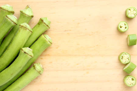 Background with raw green okra on wood with copy spaceの写真素材