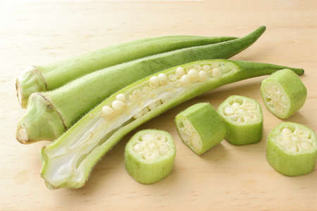 Raw green okra sliced â€‹â€‹on wooden table