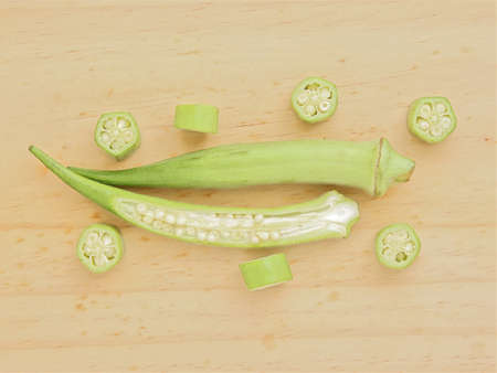 Raw green okra sliced ââon wooden tableの写真素材