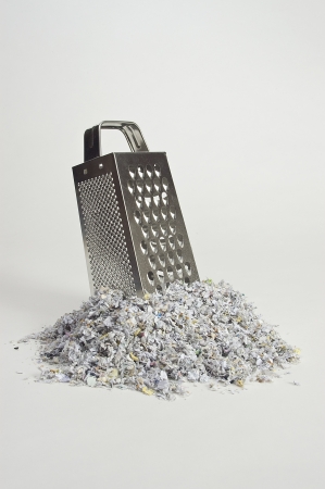 Cheese grater with paper shreds at the baseの写真素材
