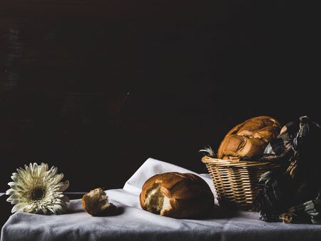 Bread on a table with a white flowerの写真素材
