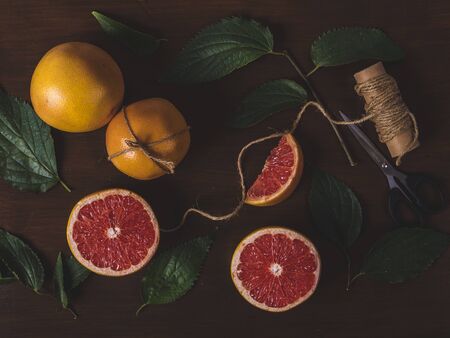 Grape fruit on a table with some leafsの写真素材