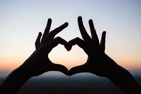 silhouette of heart shape with hands