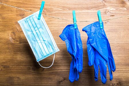 a mask and medical gloves drying on a clotheslineの写真素材