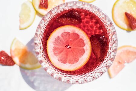 glass of red liquid and fruitsの写真素材