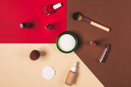 make up stuff on a brown red and cream color backgroundの写真素材