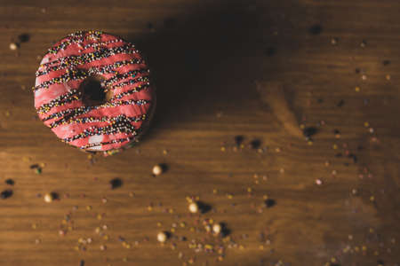 colorful donuts on a wooden table with a dark background