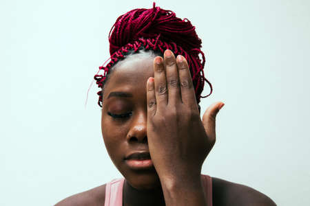 woman covering her eye with her handの写真素材