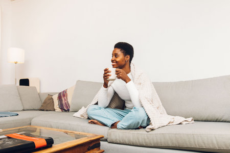 person sitting on a sofa and drinking coffeeの写真素材