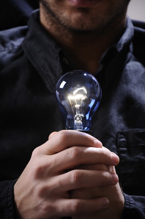 young man with light bulb in his hands and looking in camera
の写真素材