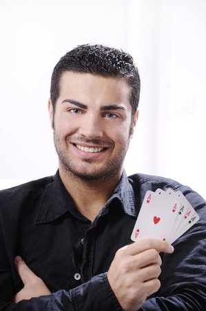 man with ace poker; four aces in hands; smiling and looking in camera.
