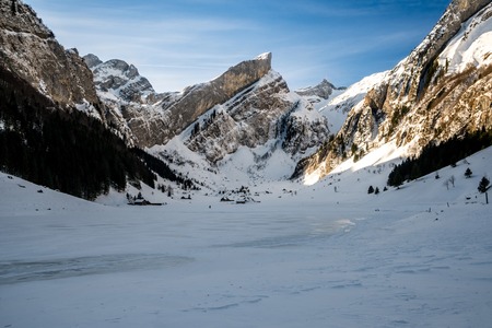 frozen lake seealpsee, swiss mountains during winterの写真素材