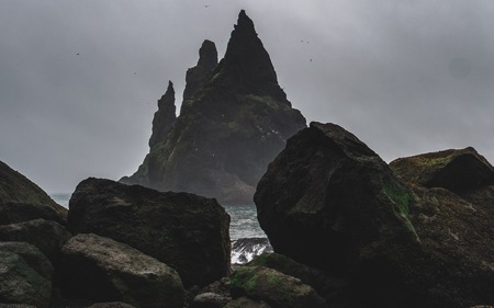 reynisdrangar with a lot of birds on it and no people without people