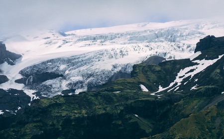 beautiful icelandic scenery with glacier and grassland, covered in clouds glacierの写真素材