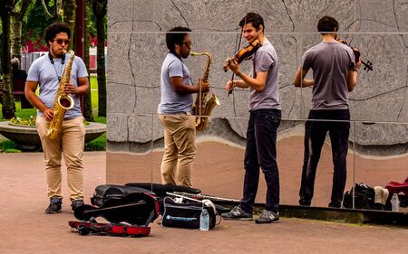 street performer in amsterdam with reflection wall, playing violin and saxophon musicのeditorial素材
