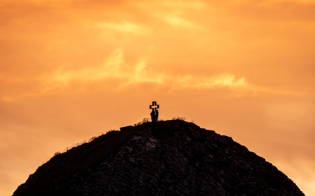 people on mountain summit peak with cross during sunset golden silhouette dramatic sunset brienzer rothorn switzerlandの写真素材