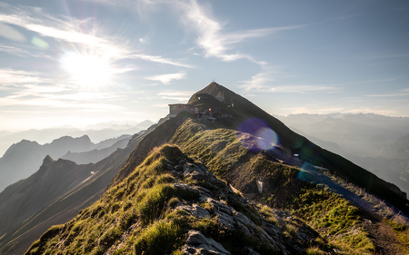 sunrise on the mountain peak with view to the mountain range of the swiss alps, sunflares mountain ridge brienzer rothorn switzerlandの写真素材
