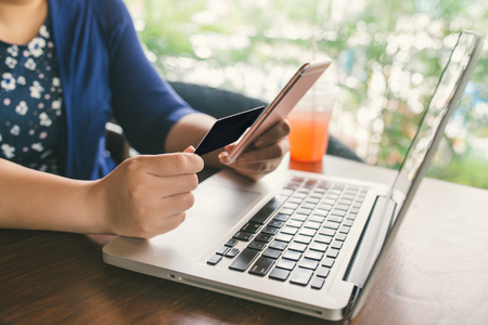 Woman hands working with a laptop in a coffee shopの写真素材