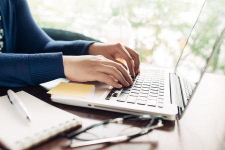 Woman hands working with a laptop in a coffee shopの写真素材