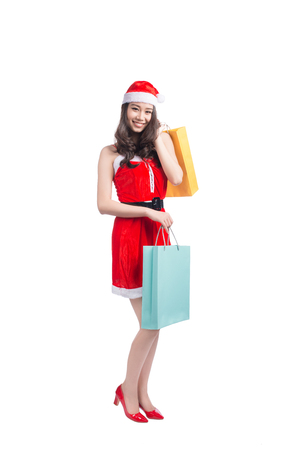 Portrait of a young smiling woman holding shopping bags before christmasの写真素材