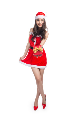 Full length portrait of a asian woman in santa claus cloth holding gift box isolated on a white backgroundの写真素材