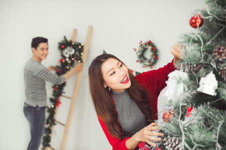Happy young asian man  near christmas tree celebrating New Yearの写真素材