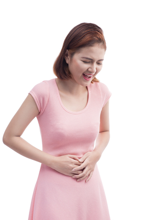 Young beautiful asian woman is having stomach ache. Isolated on white.の写真素材